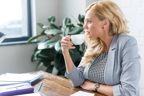 istock side view of businesswoman drinking coffee at work 928424358