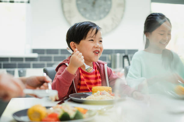 маленький мальчик наслаждаясь его перемешать фрай - asian cuisine lunch dinner food стоковые фото и изображения