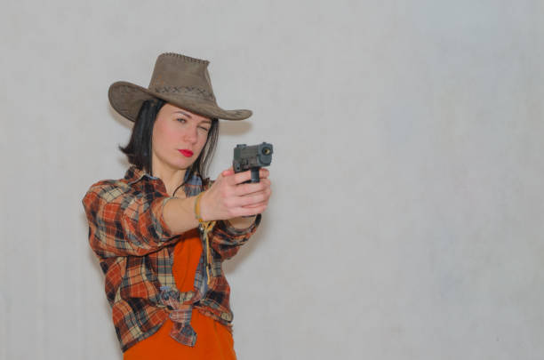 istock on grey background, cowboy girl aiming pistol 928427522
