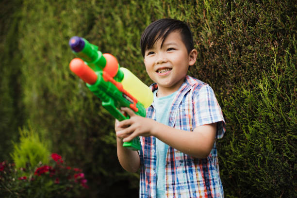 庭の水の戦いを��持っていること - toy gun ストックフォトと画像