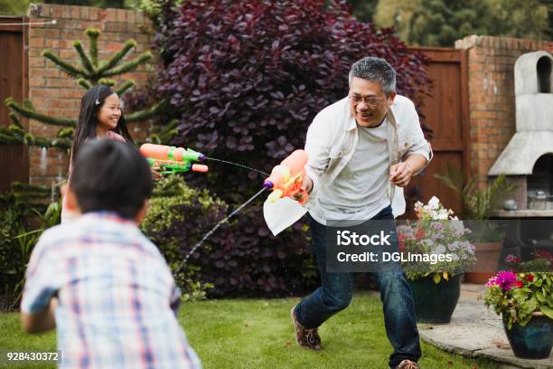 Family Having A Water Fight Stock Photo - Download Image Now - Family, Asian and Indian Ethnicities, Child