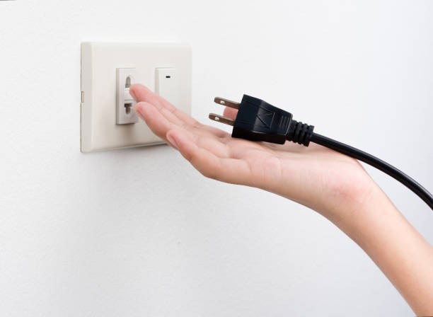 istock Plug on hand or unplug and outlet on white wall background , electric shock 928433780