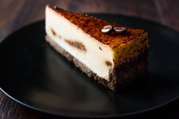 istock Coffee Cheesecake on Black Plate with Dark Wooden Surface. 928438322