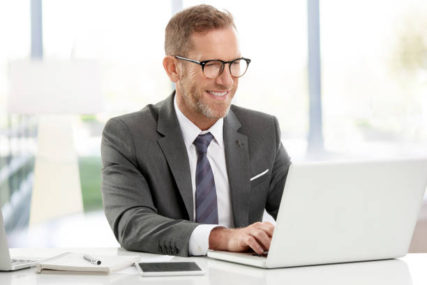 uomo d'affari che lavora su laptop in ufficio - business person isolated on white waist up business foto e immagini stock