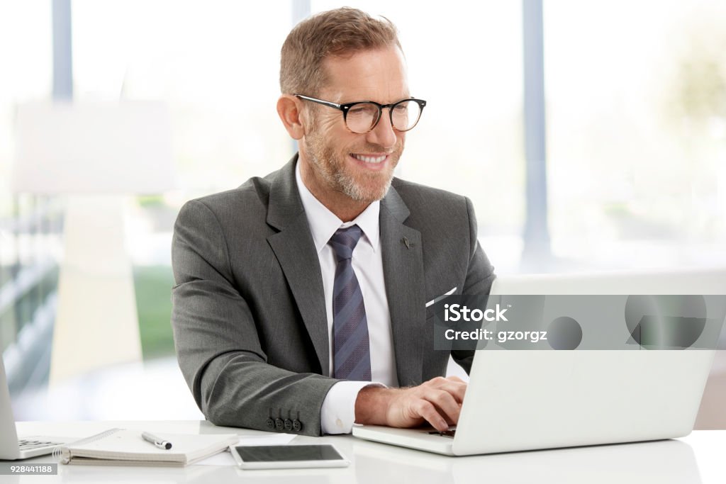 Businessman working on laptops at the office Executive senior financial director businessman doing some paperwork while sitting at desk and working on laptops. Men Stock Photo