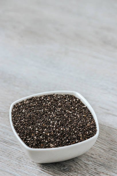 istock Superfood in a ceramic bowl. Chia seeds. Vertical image. 928442002
