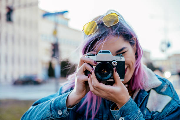 imagen de primer plano urbano femenino fotógrafo con cámara. - una sola mujer fotos fotografías e imágenes de stock