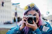 Close-up image of urban female photographer using camera.