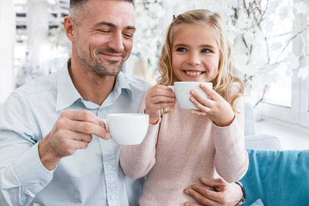istock young father and daughter drinking tea in cafe 928445104