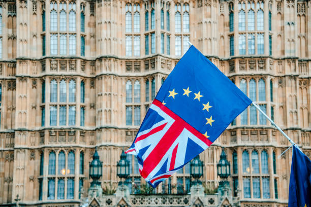 UK and EU flags merged by Houses of Parliament A flag merging the UK and EU flags, by Houses of Parliament building in London brexit stock pictures, royalty-free photos & images