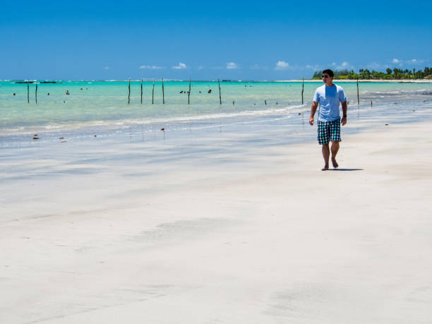 istock man walking along beach view on a summer day 928448928