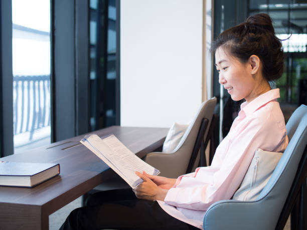 istock An asian female is reading books, study and research for her work. 928454328