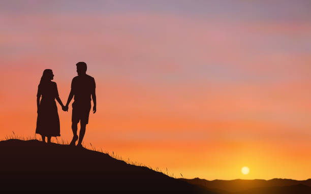 istock Silhouette couple man and woman holding hand together on hill under sunset sky background 928458246