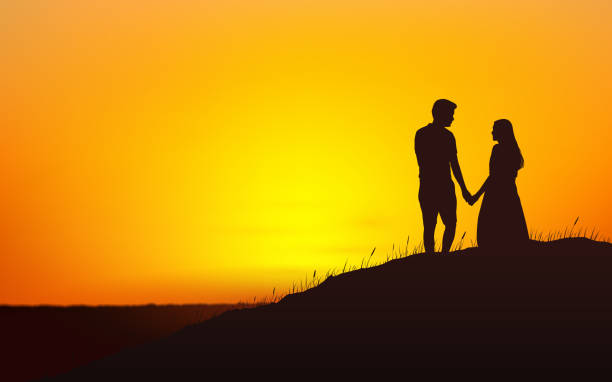 istock Silhouette couple man and woman holding hand together on hill under sunset sky background 928458384