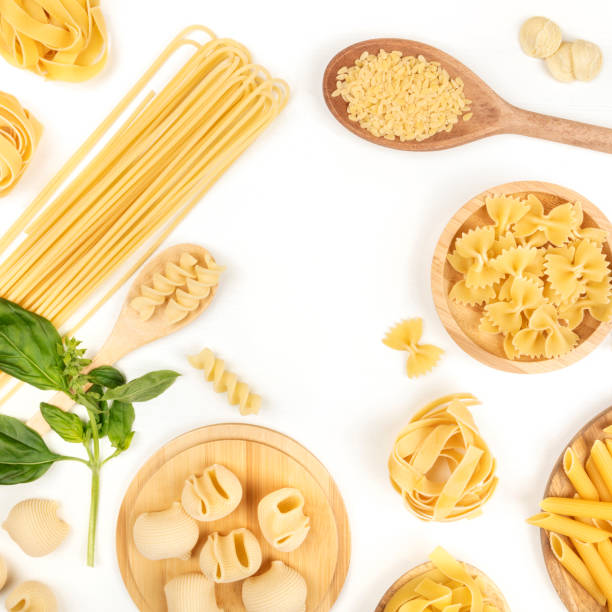 istock Overhead square photo of different types of pasta with basil on white with copy space 928458472