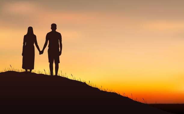 istock Silhouette couple man and woman holding hand together on hill under sunset sky background 928458514