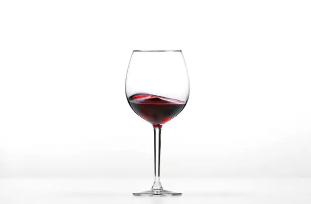 Rolling red wine on white background.
