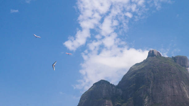 Hanggliders - Rio de Janeiro, Brazil Hanggliders close to Pedra da Gavea in Sao Conrado Beach. Rio de Janeiro, Brazil glider hang glider hanging sky stock pictures, royalty-free photos & images