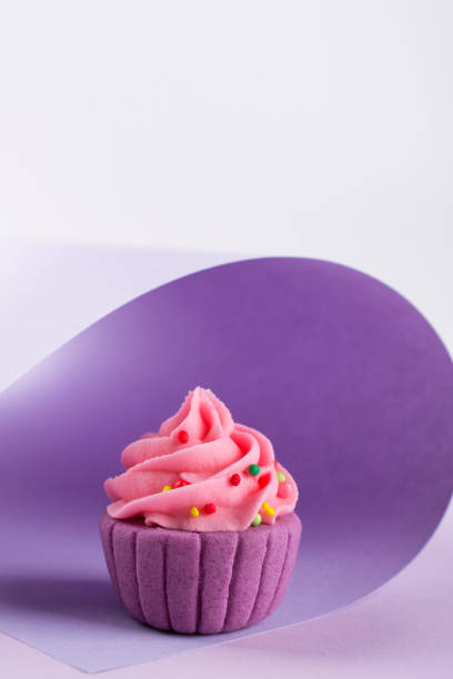 istock Purple decorative  sugar  cupcake on light background with sprinkles 928466208