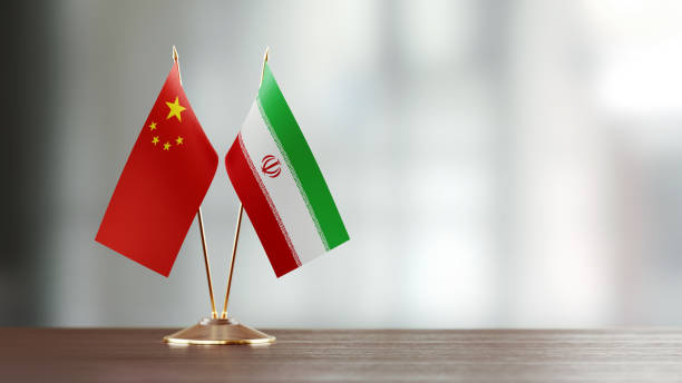 istock Chinese And Iranian Flag Pair On A Desk Over Defocused Background 928466370