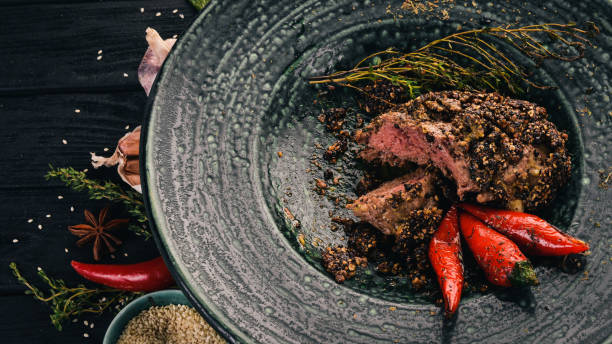 istock Pepper steak from beef. Meat. Hot appetizers. Top view. On a black wooden background. Copy space. 928469270