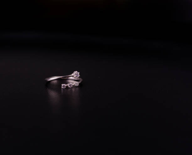 Fine silver jewelry on a black background with copy space