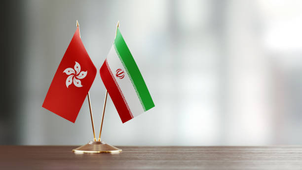 istock Hong Kong And Iranian Flag Pair On A Desk Over Defocused Background 928472836