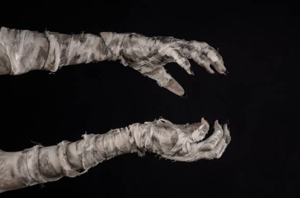 istock Halloween theme: terrible old mummy hands on a black background 928473432