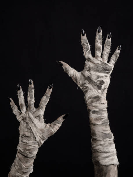 istock Halloween theme: terrible old mummy hands on a black background 928477572