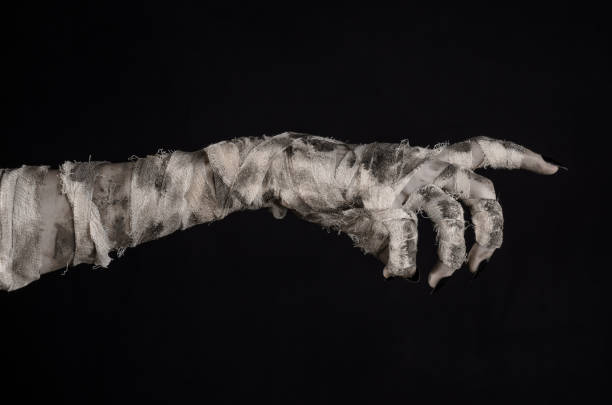istock Halloween theme: terrible old mummy hands on a black background 928478388