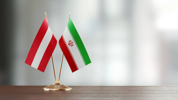 istock Austrian And Iranian Flag Pair On A Desk Over Defocused Background 928481830