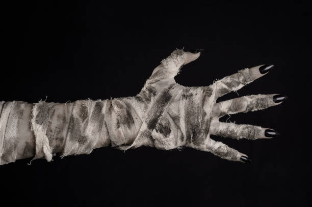 istock Halloween theme: terrible old mummy hands on a black background 928483266