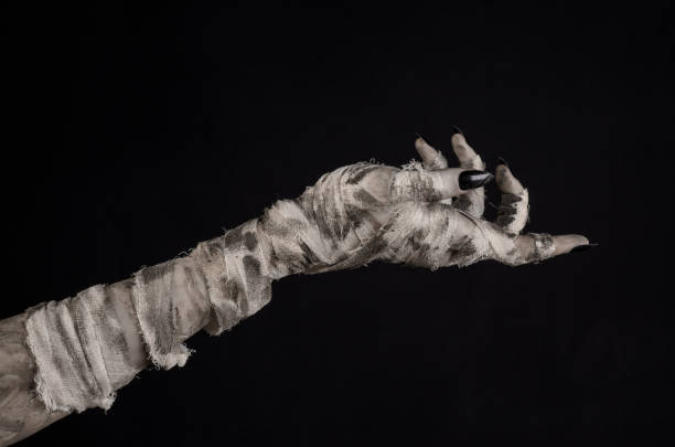 istock Halloween theme: terrible old mummy hands on a black background 928483534