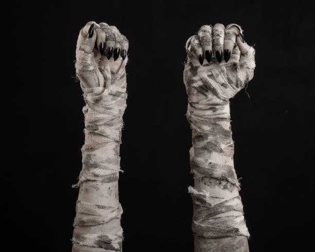 istock Halloween theme: terrible old mummy hands on a black background 928489466