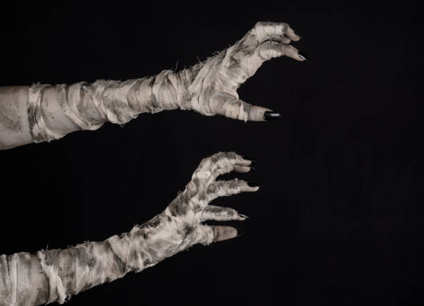 istock Halloween theme: terrible old mummy hands on a black background 928490684
