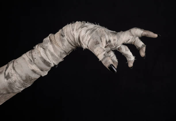 istock Halloween theme: terrible old mummy hands on a black background 928491024