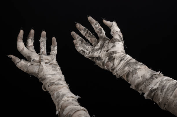 istock Halloween theme: terrible old mummy hands on a black background 928491454