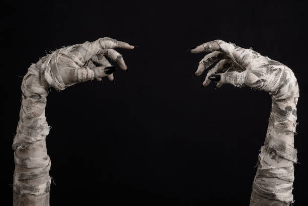 istock Halloween theme: terrible old mummy hands on a black background 928491728