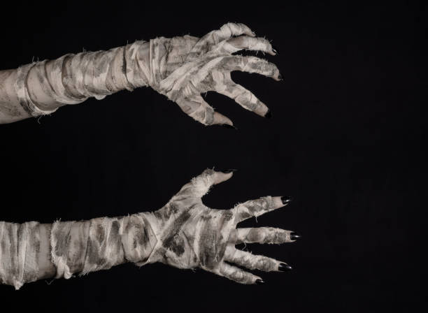istock Halloween theme: terrible old mummy hands on a black background 928496374