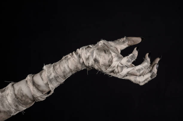 istock Halloween theme: terrible old mummy hands on a black background 928497538