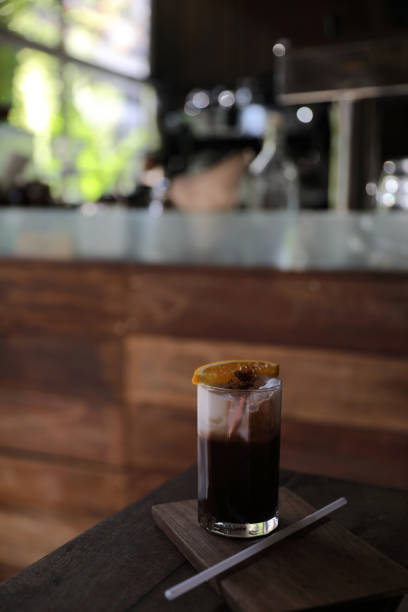 istock Ice black coffee with orange on wood background 928498288