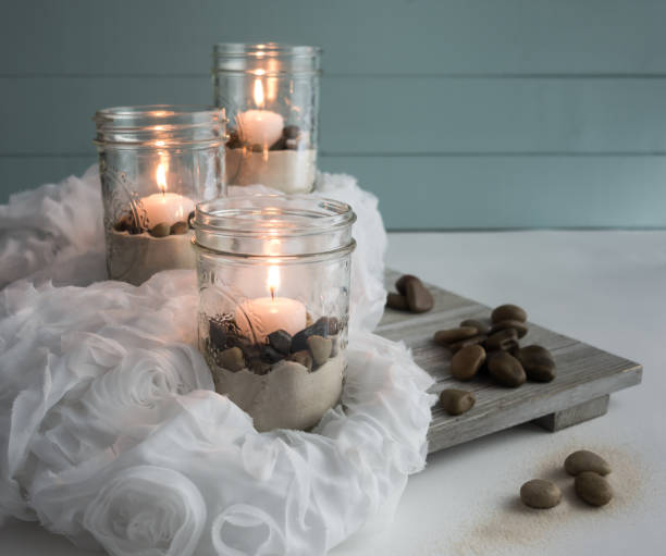istock Lit Candles with Sand and Pebbles Still Life 928499062