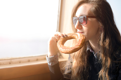 Woman drinking tea and eating bagel on fairy