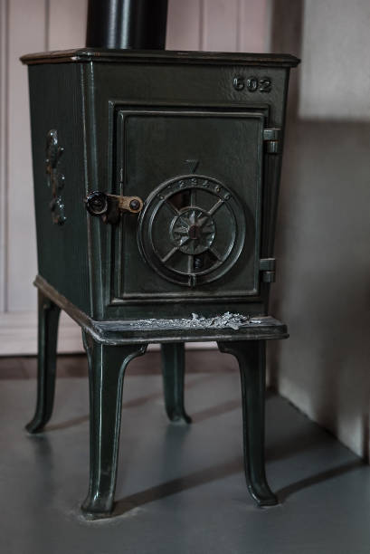 istock A closed old, black iron wood stove with ash residues 928504216
