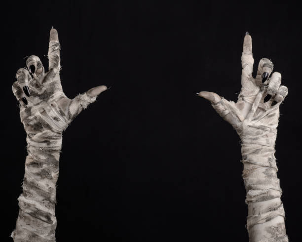 istock Halloween theme: terrible old mummy hands on a black background 928504662