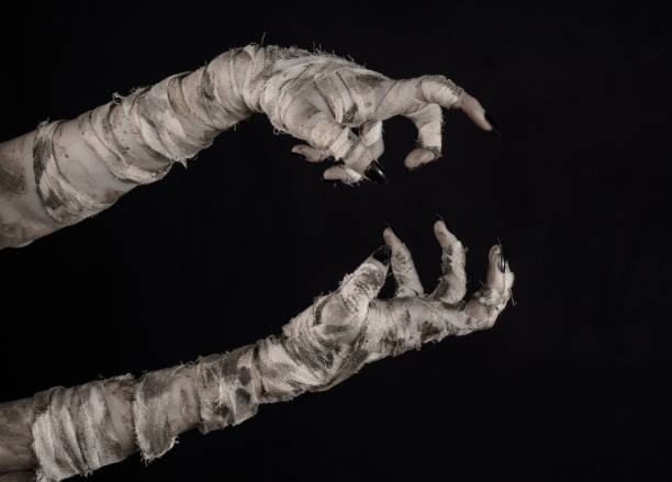 istock Halloween theme: terrible old mummy hands on a black background 928505806