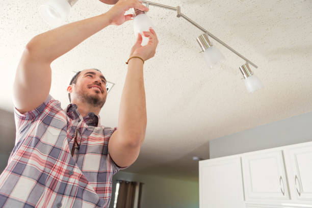 istock Confident handyman installing lighting in new home 928517720