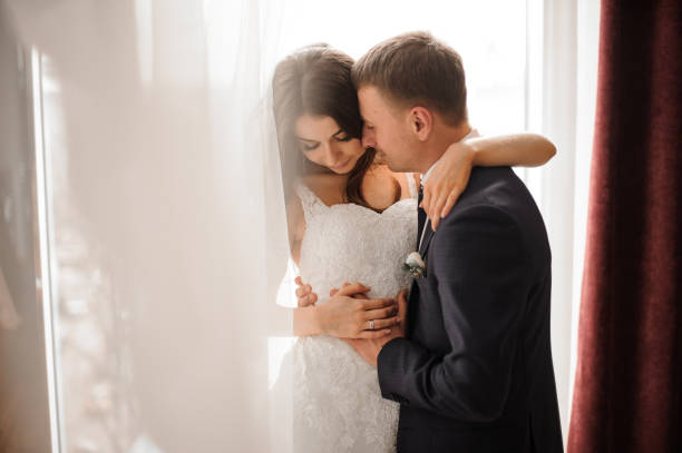 istock groom and bride romantically embracing against white background 928524274