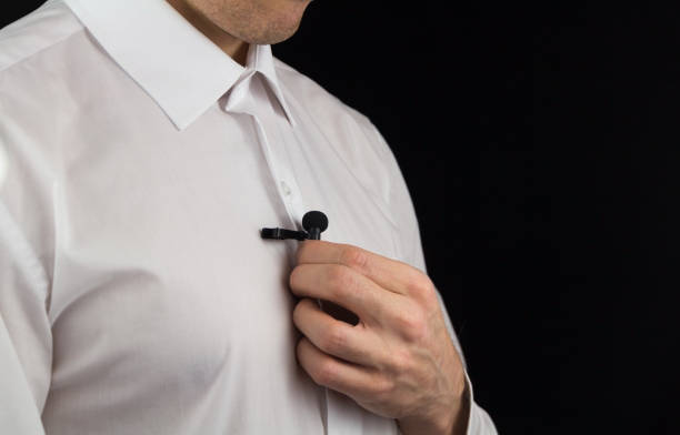 a man puts on lavalier microphone, preparation for interview - lapel imagens e fotografias de stock