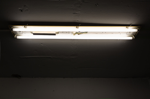 Fluorescent light on cement ceiling, industrial building